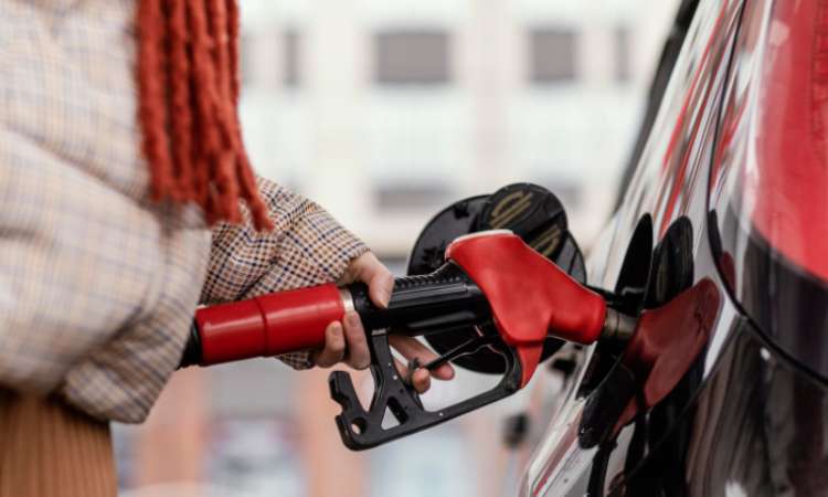 persona llena su tanque tras calcular el consumo de combustible